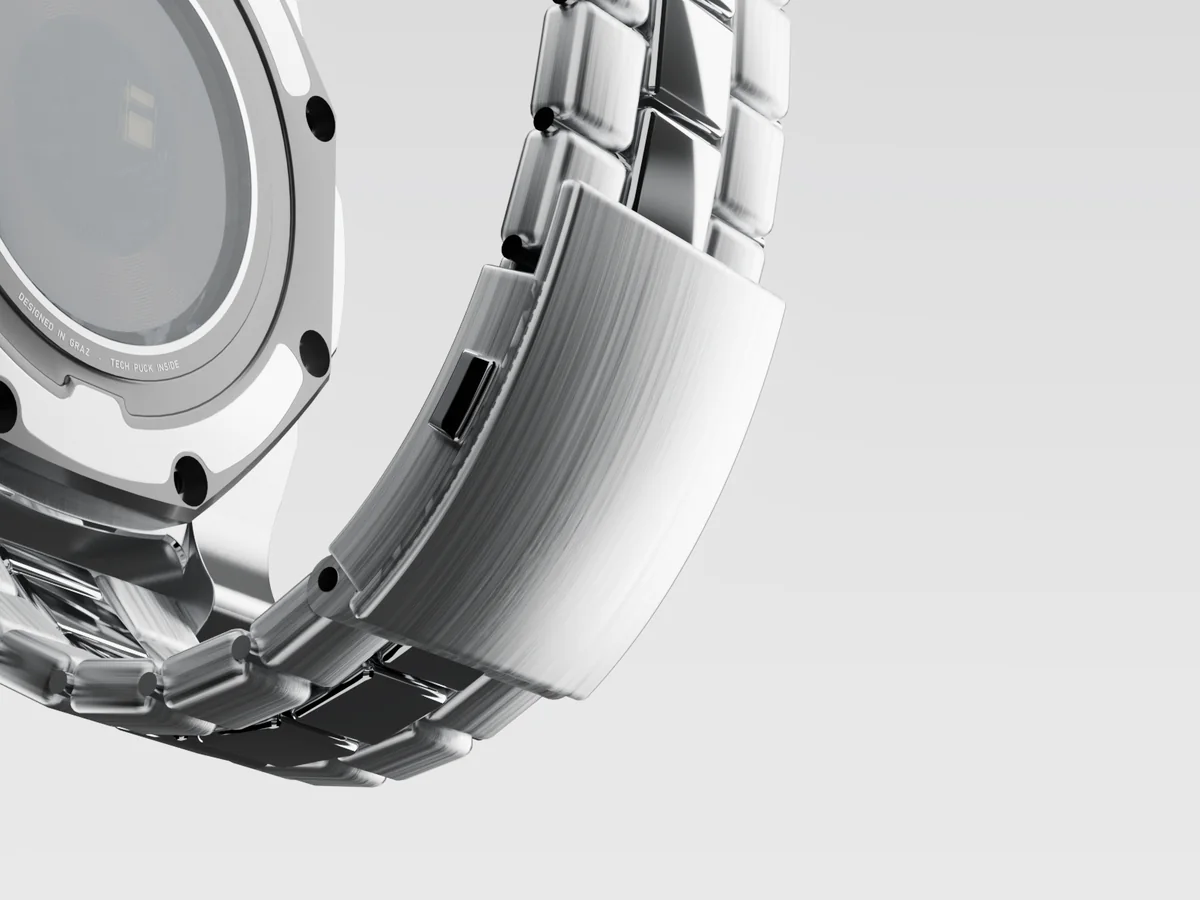 Close-up of the bracelet's brushed folding clasp and its release button.